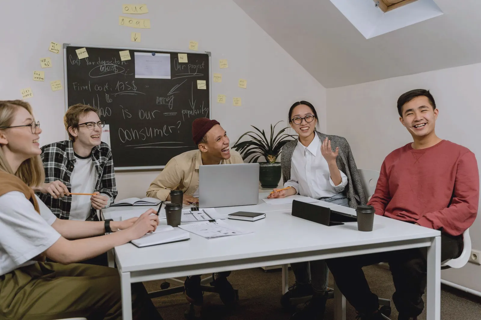 A team laughs together over a working session in a loft office.